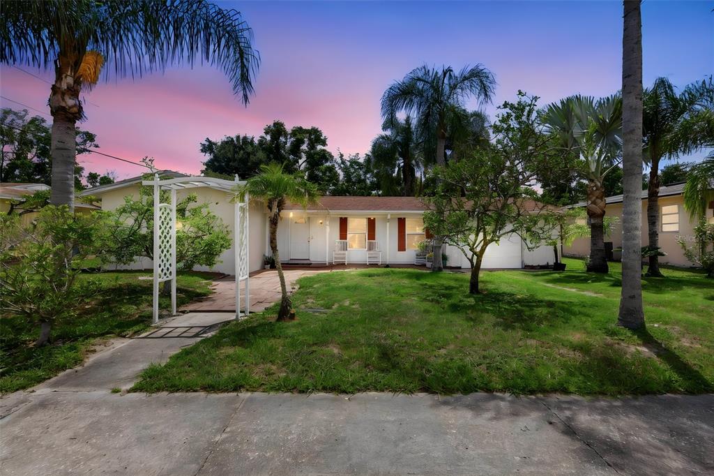 A single-story house with a white exterior, red shutters, and a front yard with palm trees — 709 HAGER STREET, DELTONA, FL