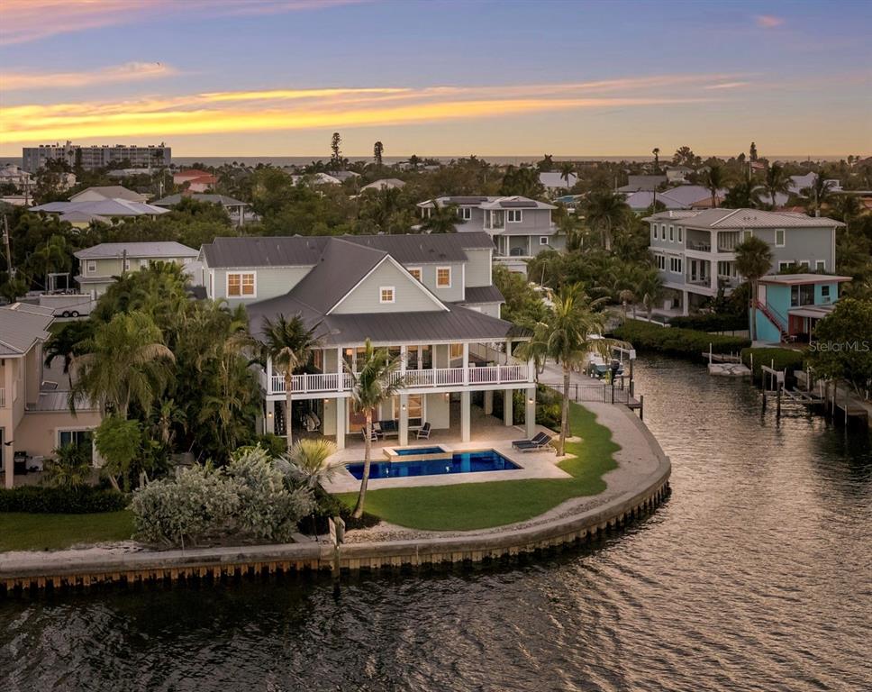 An aerial view of a multi-story house with a pool, balcony, and waterfront bulkhead — 526 56TH STREET, HOLMES BEACH, FL