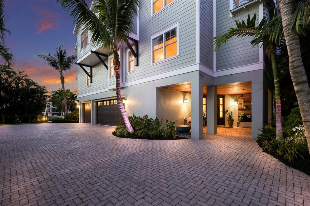 A multi-story house with light siding features a paved driveway, a garage, and a covered entryway — 526 56TH STREET, HOLMES BEACH, FL