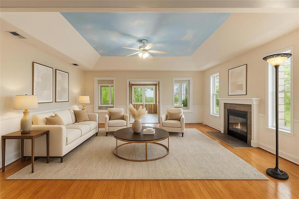 A living room features a tray ceiling with a sky mural, fireplace, and hardwood floors — 15000 W HWY 318, WILLISTON, FL