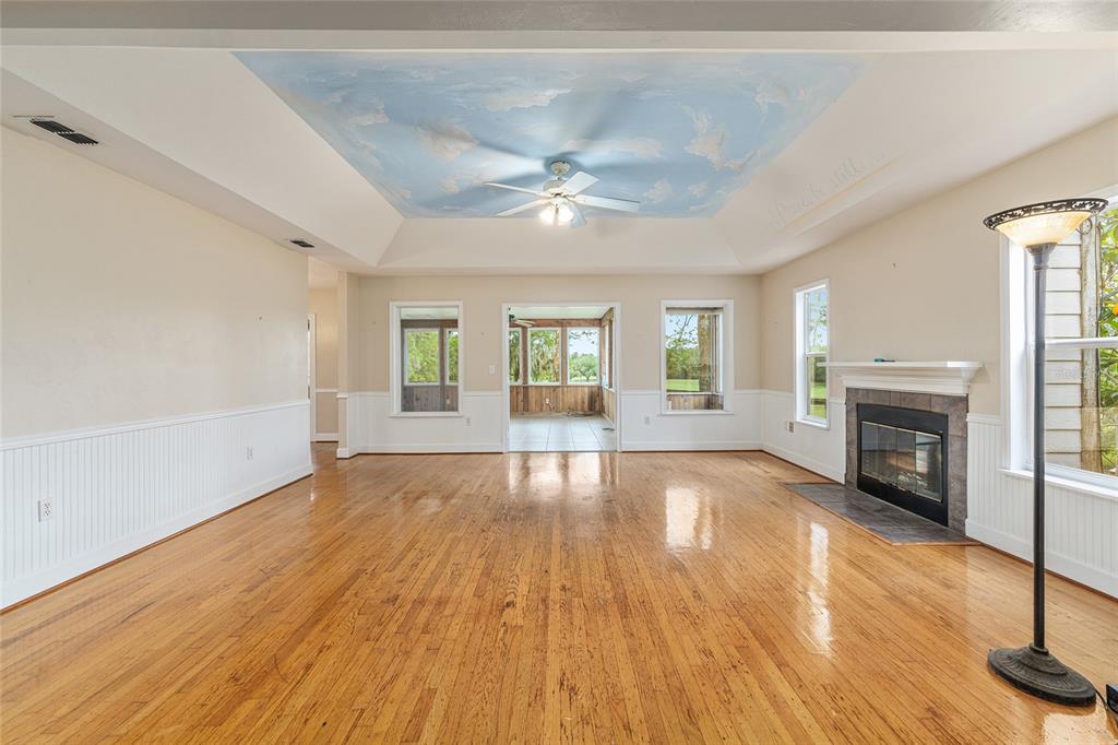 A living room with hardwood floors, a fireplace, and a painted cloud ceiling — 15000 W HWY 318, WILLISTON, FL