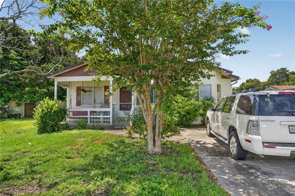 A single-story house with a front porch, a large tree, and a parked SUV — 840 NEUSE AVENUE, ORLANDO, FL