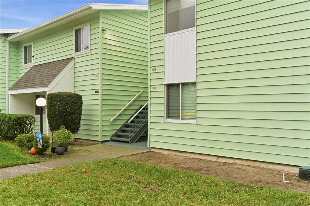 A two-story apartment building with light green siding and an exterior staircase — 521 MIDWAY DRIVE UNIT B, OCALA, FL