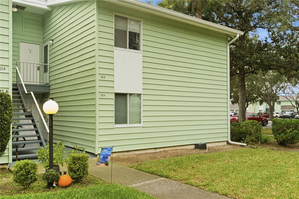 A two-story light green apartment building with an exterior staircase and a concrete walkway — 521 MIDWAY DRIVE UNIT B, OCALA, FL