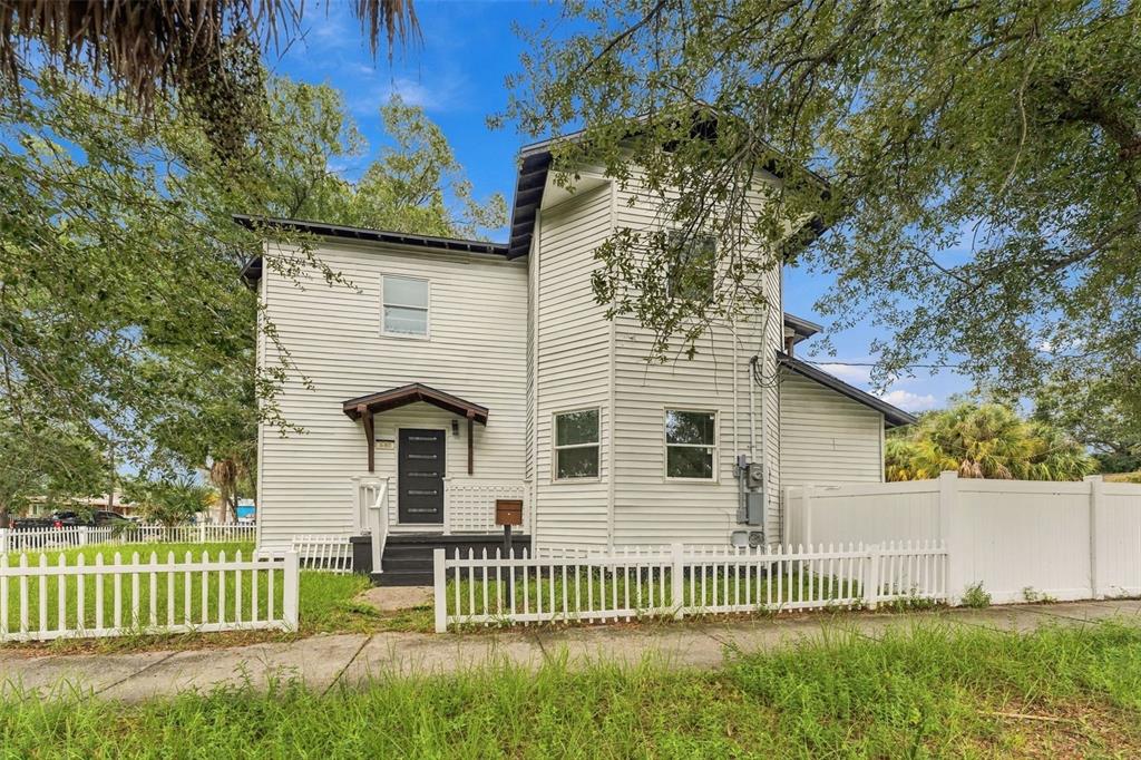 A room with light wood floors, a cowhide rug, an arcade cabinet, and a staircase — 680 25TH AVENUE S, ST PETERSBURG, FL