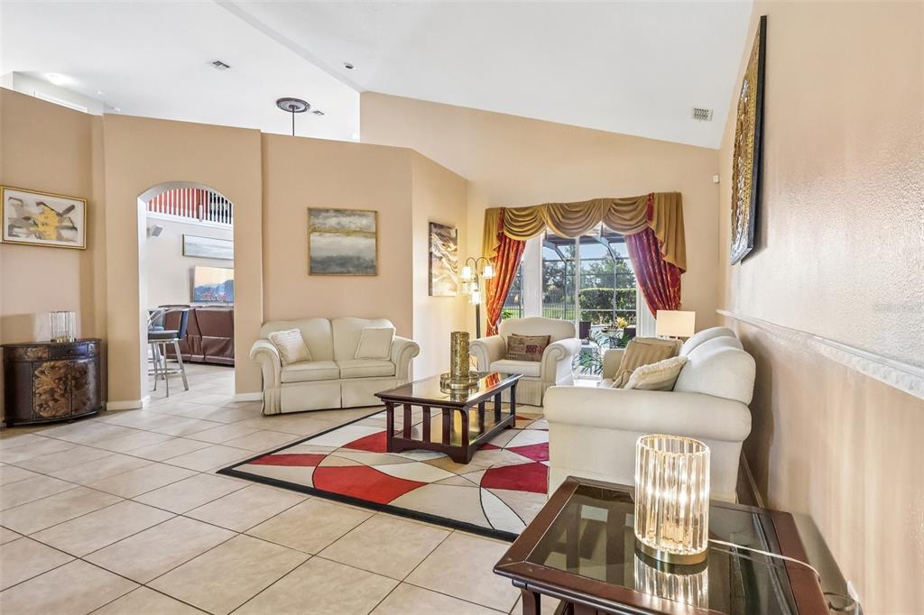 A living room features tile floors, a vaulted ceiling, and a red and white area rug — 84 BRAELOCK DRIVE, OCOEE, FL