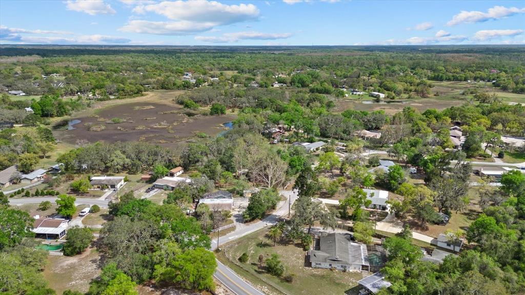An aerial view shows houses scattered among trees and a large wetland area — INDALE DRIVE, NEW PORT RICHEY, FL