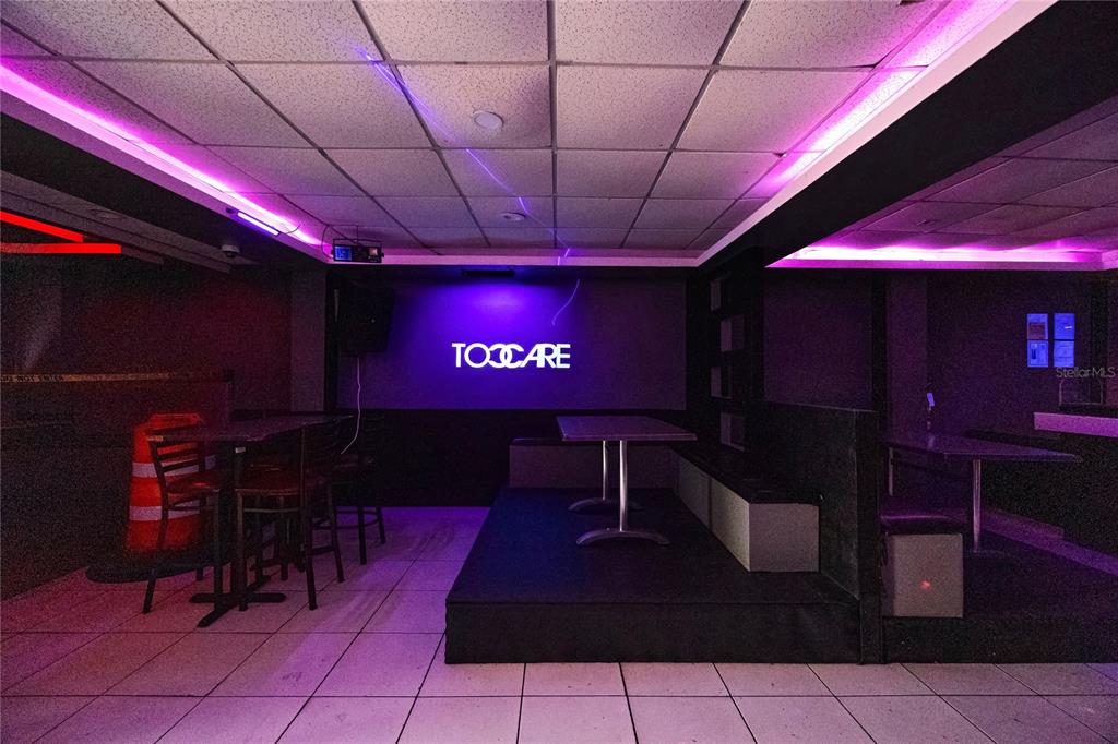 A dimly lit room features tiled floors, a raised platform with tables, and purple accent lighting — 239 ELEANOR ROOSEVELT AVENUE, SAN JUAN, PR
