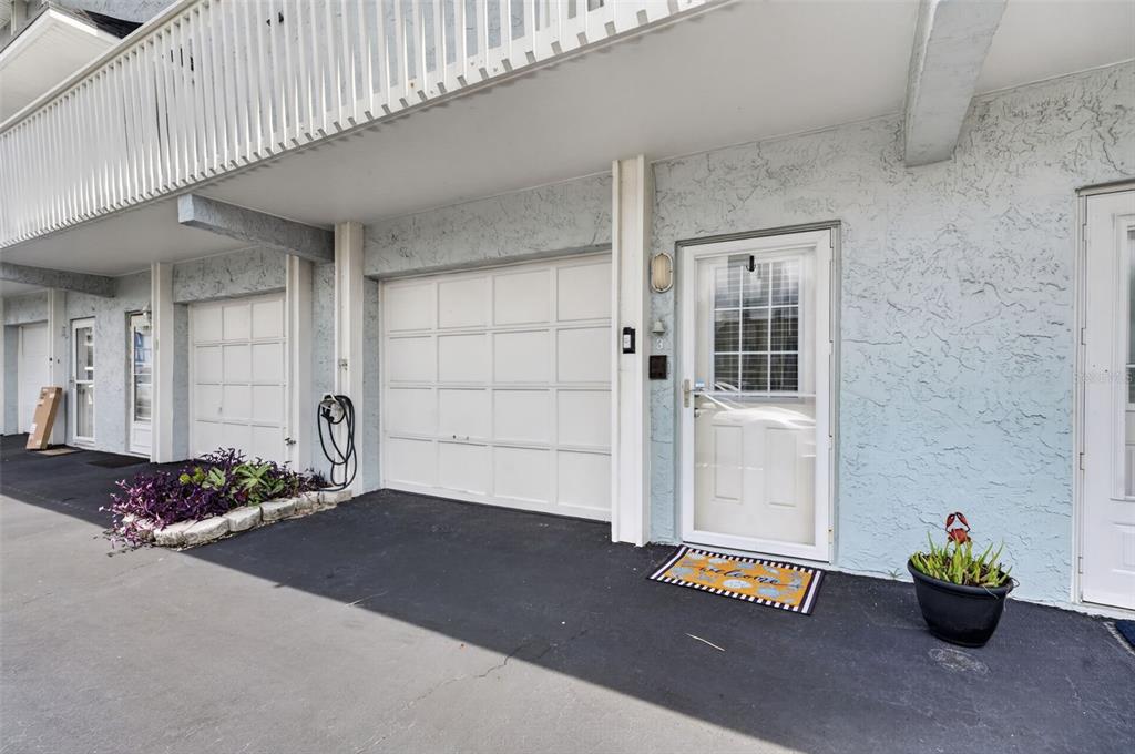 A row of townhome units with white garage doors, glass storm doors, and paved parking spaces — 4789 S ATLANTIC AVENUE UNIT 3, PONCE INLET, FL