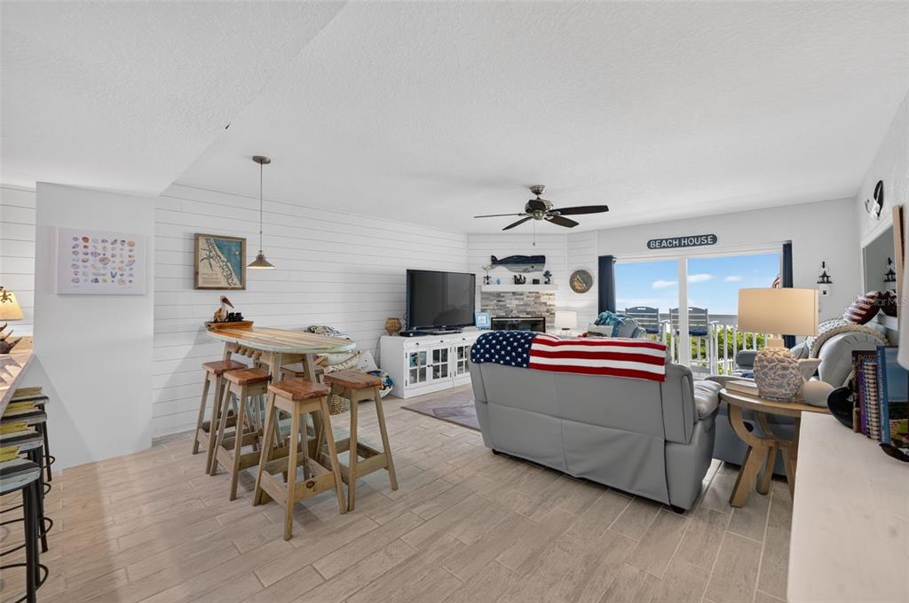 A living room features gray leather sofas, a fireplace, a ceiling fan, and a balcony view — 4789 S ATLANTIC AVENUE UNIT 3, PONCE INLET, FL