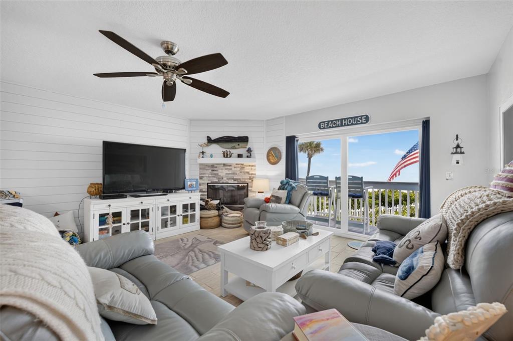 A staircase with wood-look tile steps sits beside a wooden mirror and a storage shelf — 4789 S ATLANTIC AVENUE UNIT 3, PONCE INLET, FL