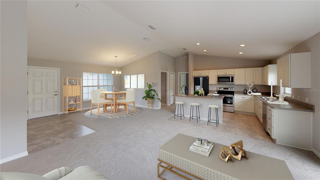 An open-concept living area features a kitchen with light cabinets, a dining space, and carpet — 1699 NE 161ST STREET, CITRA, FL