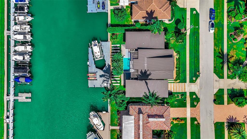 An aerial view shows a waterfront house with a private dock and multiple docked boats — 870 PARTRIDGE COURT, MARCO ISLAND, FL