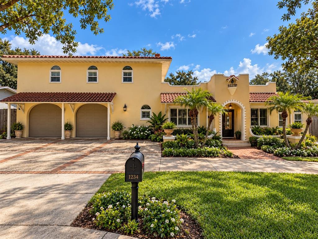 A yellow stucco house with a tiled roof, palm trees, and a concrete driveway — 30 KREAMER AVENUE, TARPON SPRINGS, FL