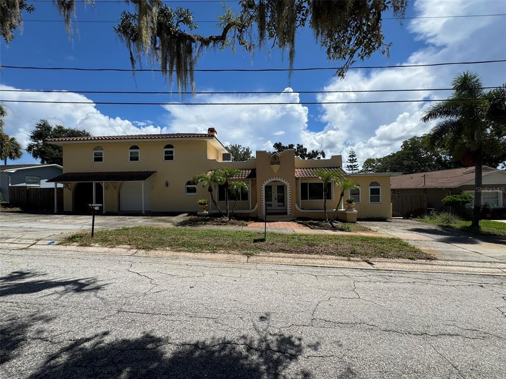 A kitchen features wood cabinets, dark countertops, a stainless steel dishwasher, and gray wood-look flooring — 30 KREAMER AVENUE, TARPON SPRINGS, FL