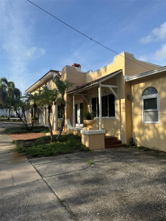 A kitchen features wood cabinets, dark countertops, a tile backsplash, and wood-look flooring — 30 KREAMER AVENUE, TARPON SPRINGS, FL