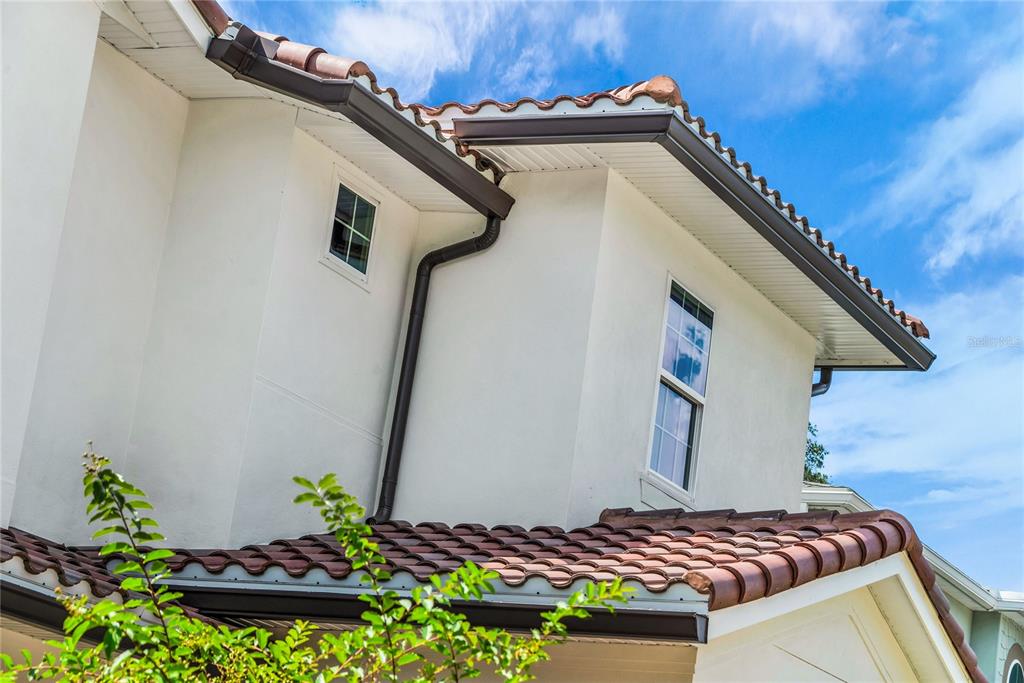 A low-angle exterior view shows a white stucco house with a brown tile roof — 1430 STETSON STREET, ORLANDO, FL