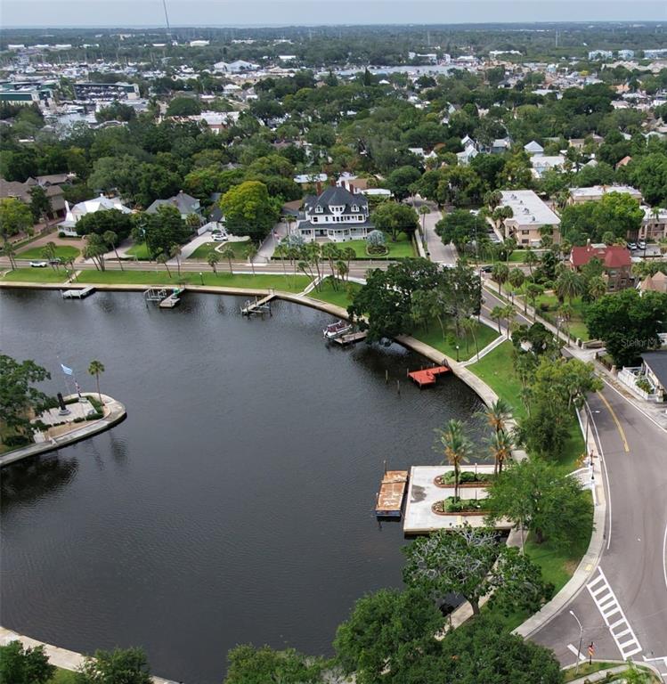 An aerial view shows a waterfront property with a large house, docks, and surrounding trees — 0 W LEMON STREET, TARPON SPRINGS, FL