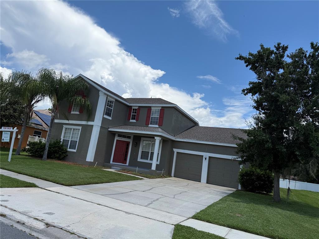 A two-story house with a gray stucco exterior, red shutters, and a two-car garage — 3081 MARSHFIELD PRESERVE WAY, KISSIMMEE, FL