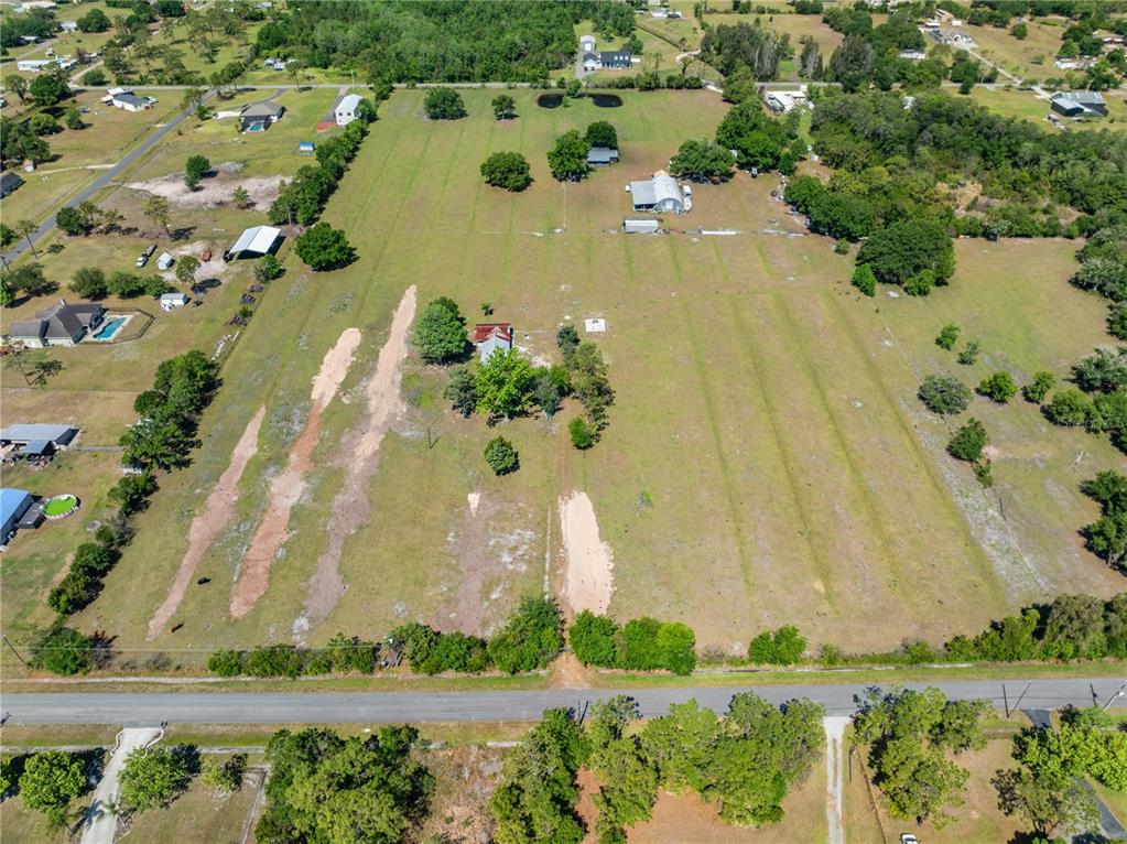 An aerial view shows a large, grassy rural lot with several outbuildings and scattered trees — 0 LA SALLE AVENUE, ST CLOUD, FL