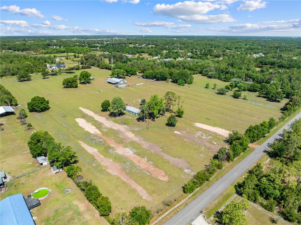 An aerial view shows a rural property with a house, outbuildings, and open fields — 0 LA SALLE AVENUE, ST CLOUD, FL