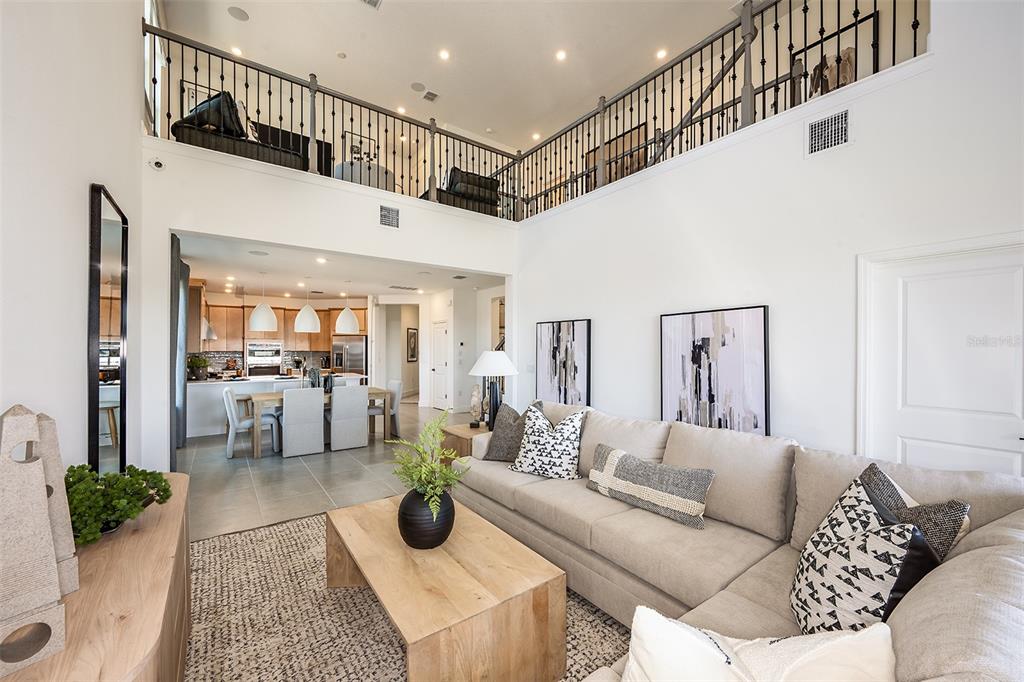 A modern kitchen features light wood cabinets, white quartz countertops, stainless steel appliances, and pendant lighting — 19337 LOCHSIDE LANE, MOUNT DORA, FL