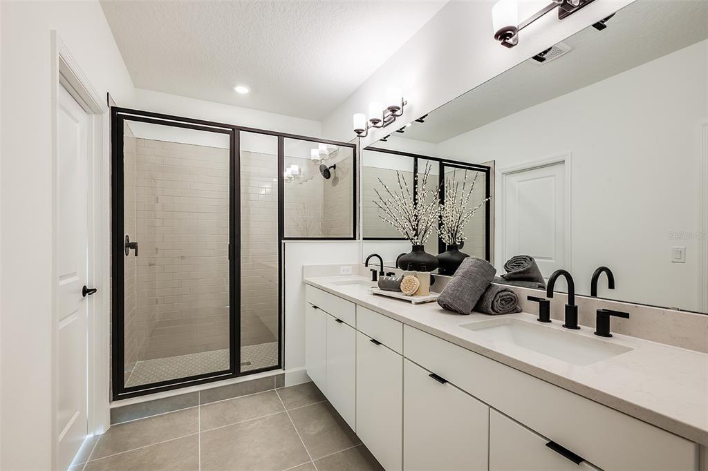 A modern kitchen features light wood cabinets, white countertops, a large island, and pendant lighting — 19337 LOCHSIDE LANE, MOUNT DORA, FL