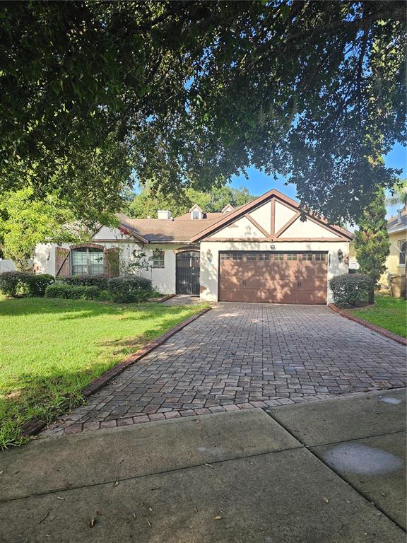 A single-story house with a brick driveway, a two-car garage, and a front lawn — 33116 IRONGATE DRIVE, LEESBURG, FL