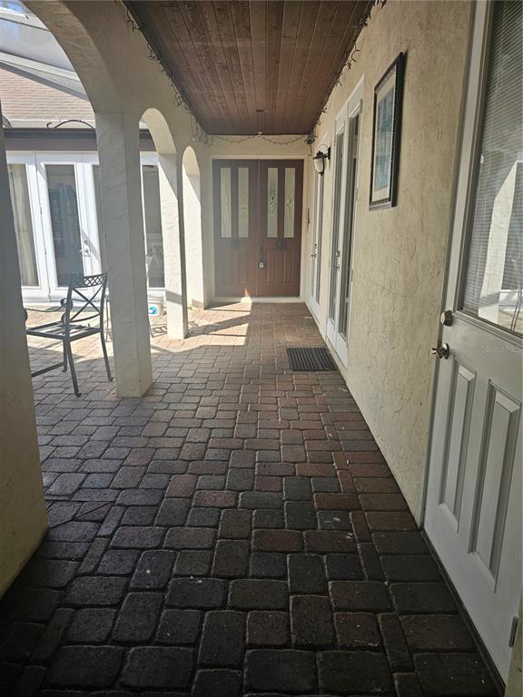 A covered brick patio features arched columns, a wood-paneled ceiling, and double entry doors — 33116 IRONGATE DRIVE, LEESBURG, FL