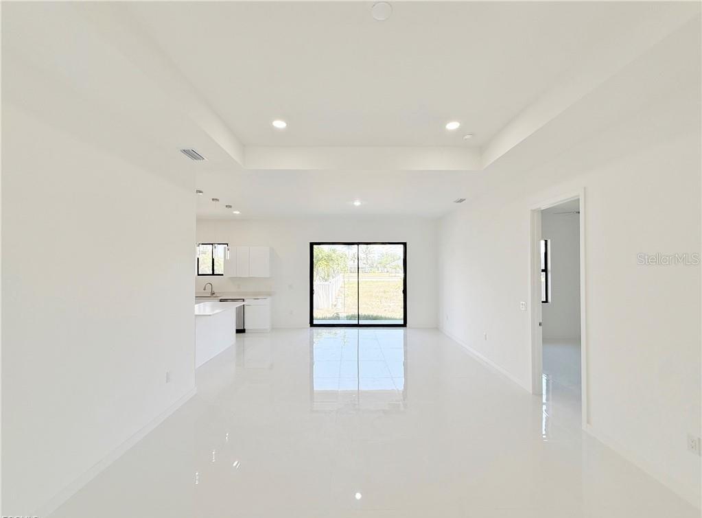 A bright, open-concept living area features white tile floors, recessed lighting, and a modern kitchen — 4331 NW 31ST TERRACE, CAPE CORAL, FL