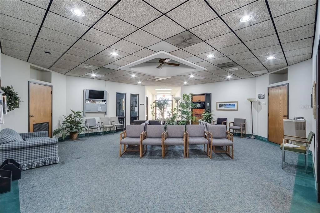 A waiting room features a drop ceiling, gray carpet, and multiple rows of chairs — 6801 US-27 N UNIT B2, SEBRING, FL