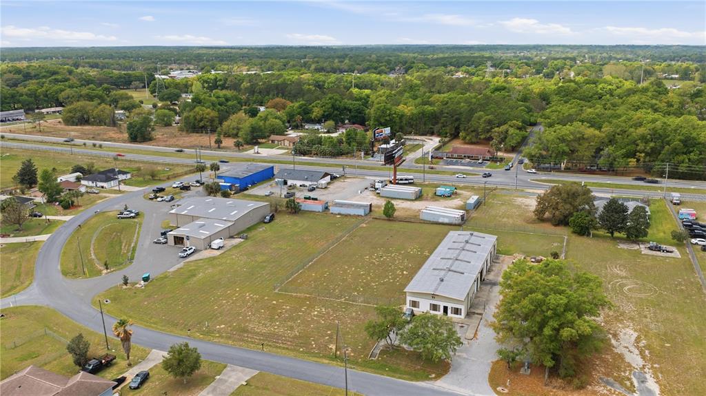 An aerial view shows commercial buildings, parking lots, and open land near a highway — 0000 ALMOND DRIVE RUN, OCALA, FL