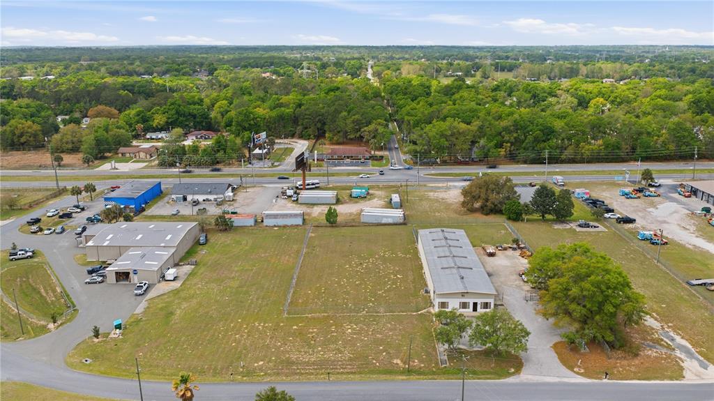 An aerial view shows two commercial buildings separated by a large, vacant grassy lot — 0000 ALMOND DRIVE RUN, OCALA, FL