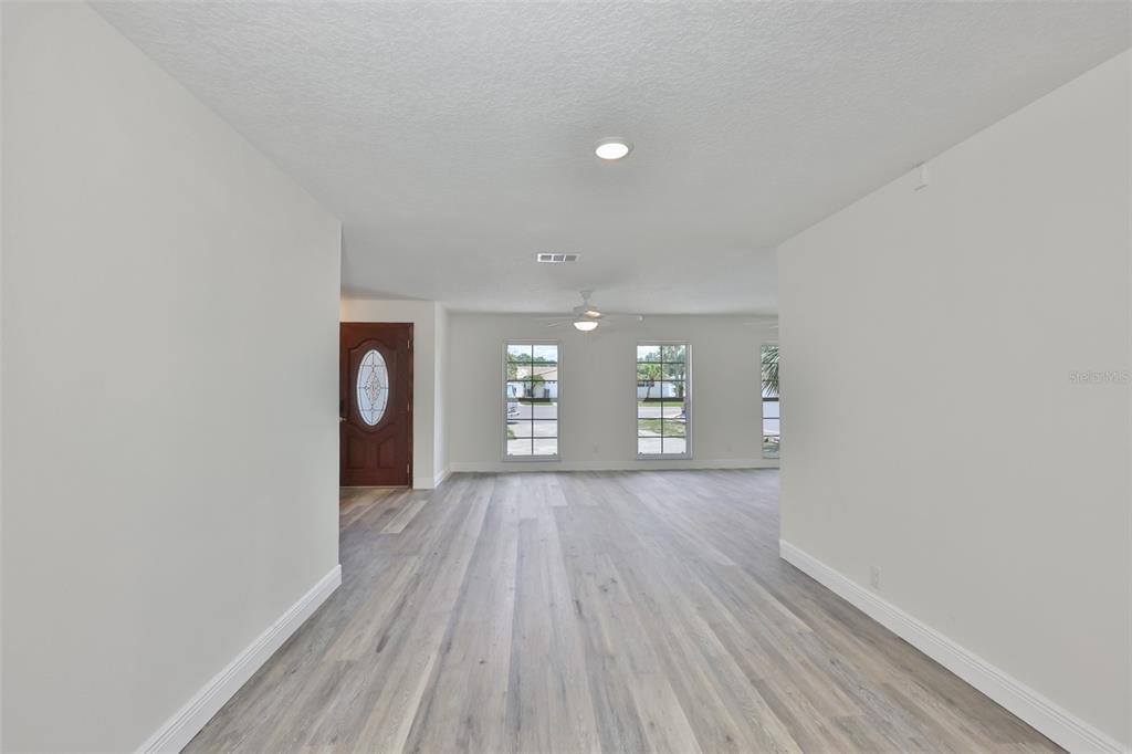 The front exterior of a brick house features a wooden door and two windows — 8410 LAVA PLACE, TAMPA, FL