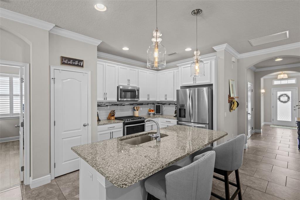 A kitchen with white cabinets, granite countertops, a center island, and stainless steel appliances — 14426 TRAILS EDGE BOULEVARD, ODESSA, FL