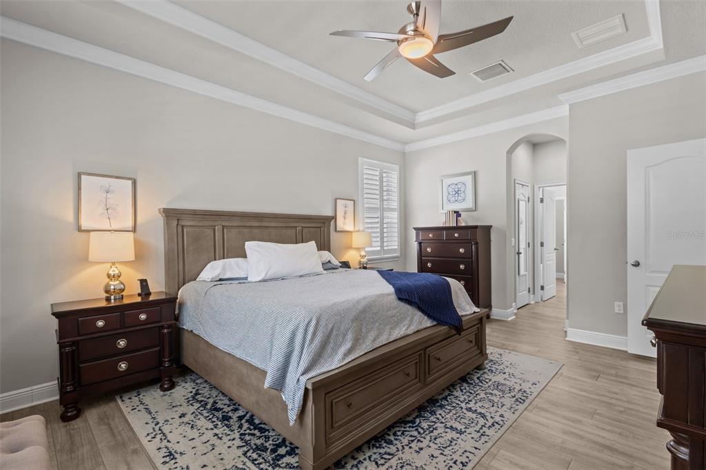 A bedroom features a wooden bed frame, a dark dresser, and a patterned area rug — 14426 TRAILS EDGE BOULEVARD, ODESSA, FL