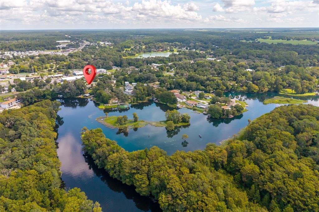 An aerial view shows a house marked by a red pin beside a lake — 20368 THE GRANADA, DUNNELLON, FL