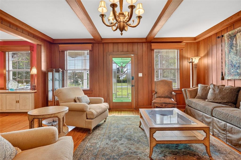 A living room features wood-paneled walls, a coffered ceiling, a chandelier, and a stained-glass door — 20368 THE GRANADA, DUNNELLON, FL