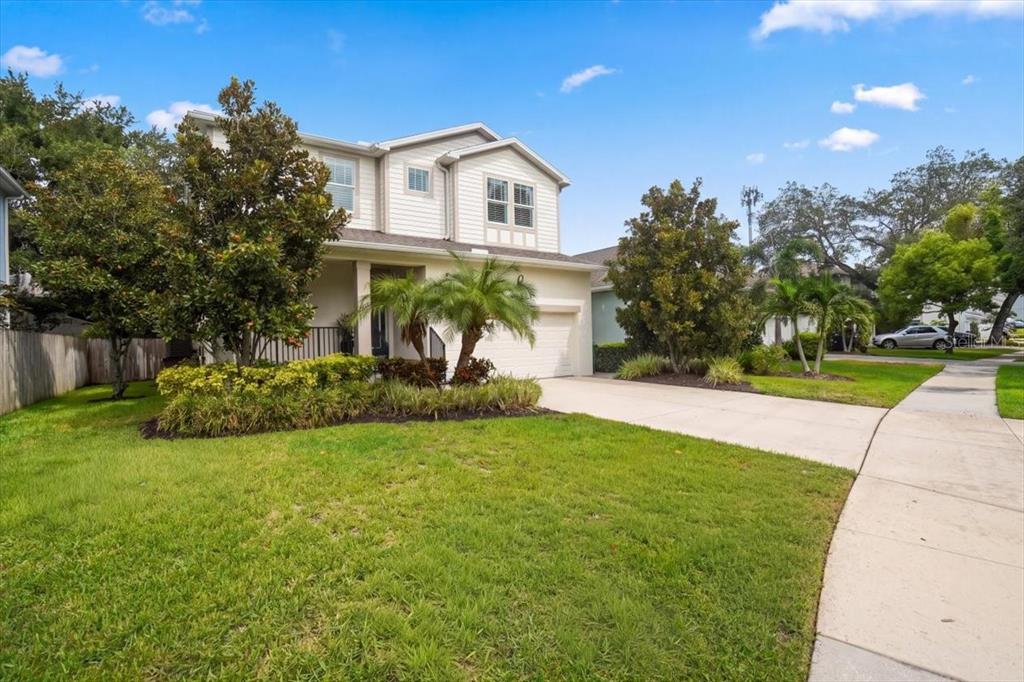 A two-story suburban house with light siding, a front porch, and a concrete driveway — 3615 W RENELLIE CIRCLE, TAMPA, FL