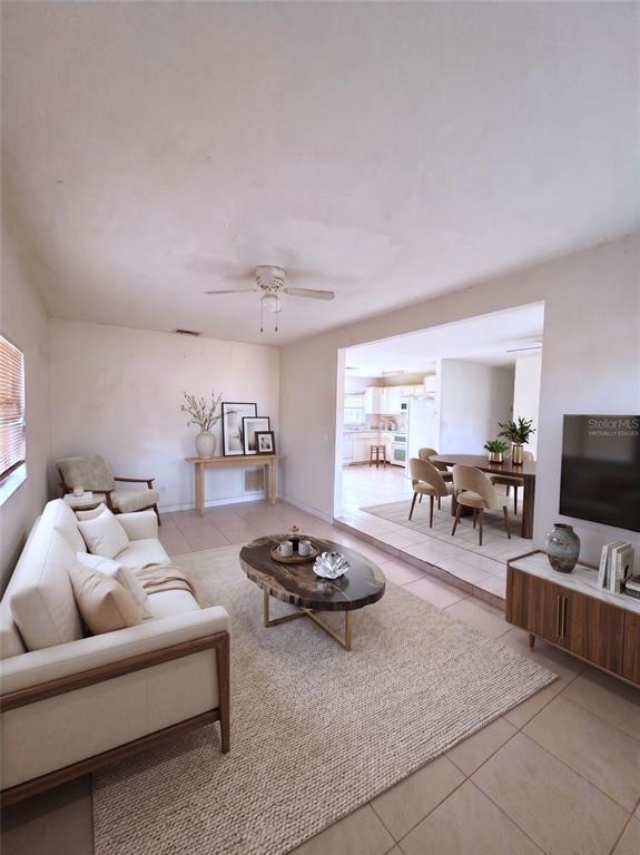 This living room features a white sofa, a wood coffee table, and an adjacent dining area — 1636 SE ARAPAHO AVENUE, STUART, FL