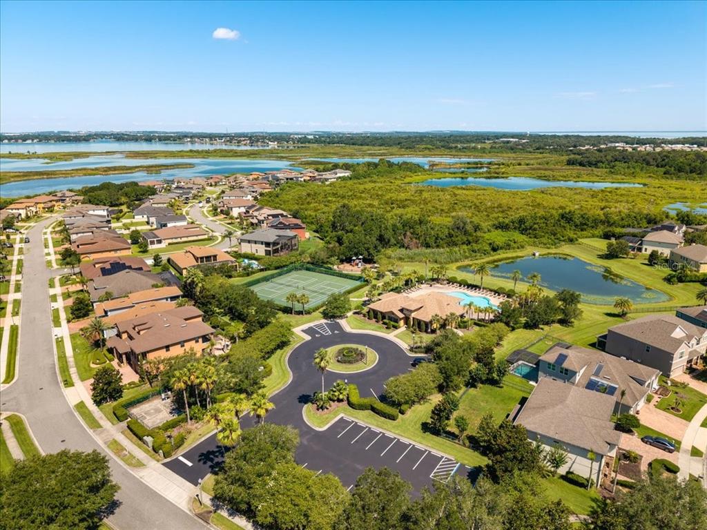 An aerial view of a residential neighborhood featuring a community pool, tennis court, and pond — 617 MARSH REED DRIVE, WINTER GARDEN, FL