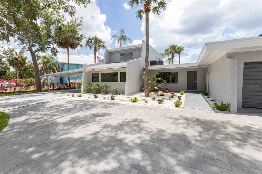 A modern house exterior features a paved driveway, a carport, and a landscaped front yard — 5303 SEA FOREST DRIVE, NEW PORT RICHEY, FL