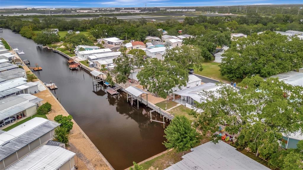 An aerial view shows a canal lined with mobile homes, boat docks, and mature trees — 106 N SAINT GEORGE CIRCLE, APOLLO BEACH, FL