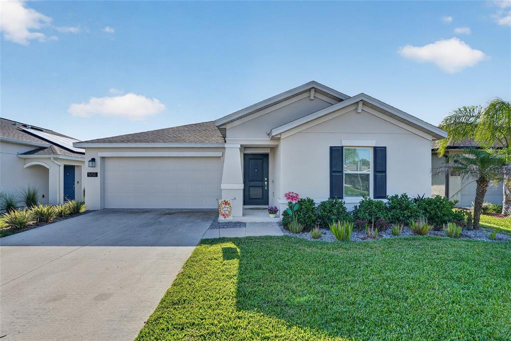 An aerial view shows a suburban house with a solar-paneled roof near a lake — 5151 FOUR STRAND COURT, ST CLOUD, FL