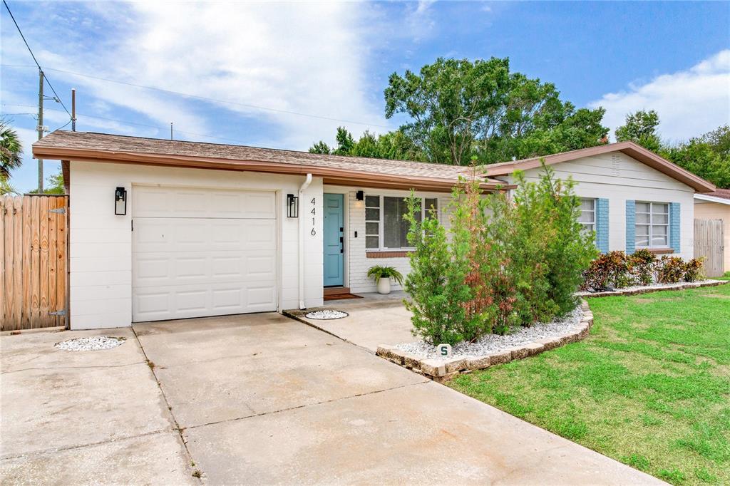 A single-story house with a white brick exterior, a light blue door, and a concrete driveway — 4416 W BAY COURT AVENUE, TAMPA, FL