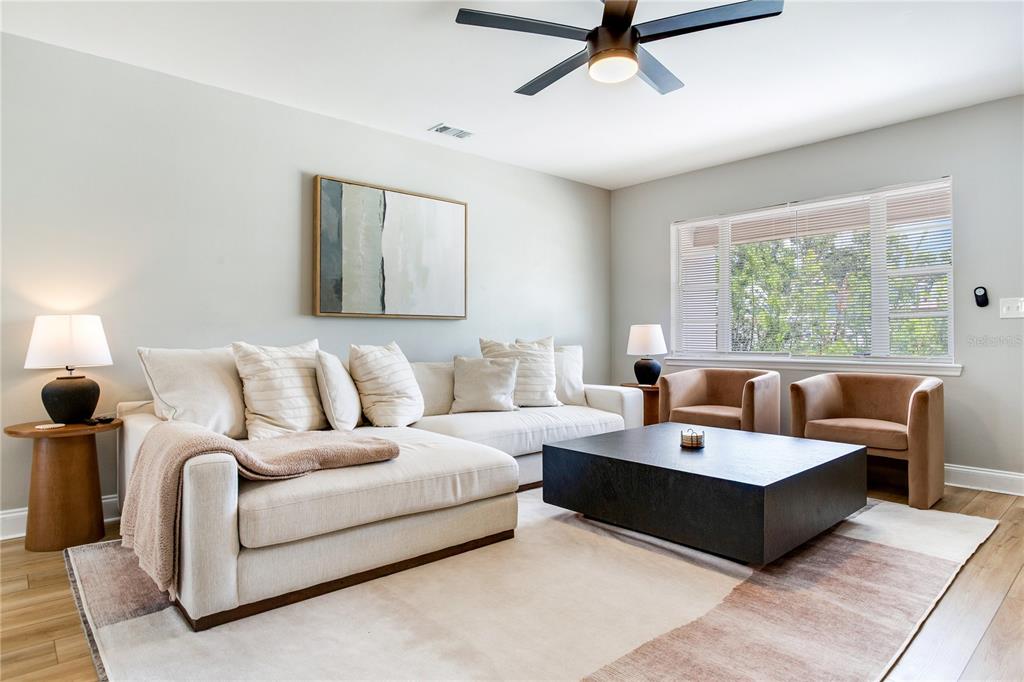A living room features a cream sectional sofa, a black coffee table, and two armchairs — 4416 W BAY COURT AVENUE, TAMPA, FL
