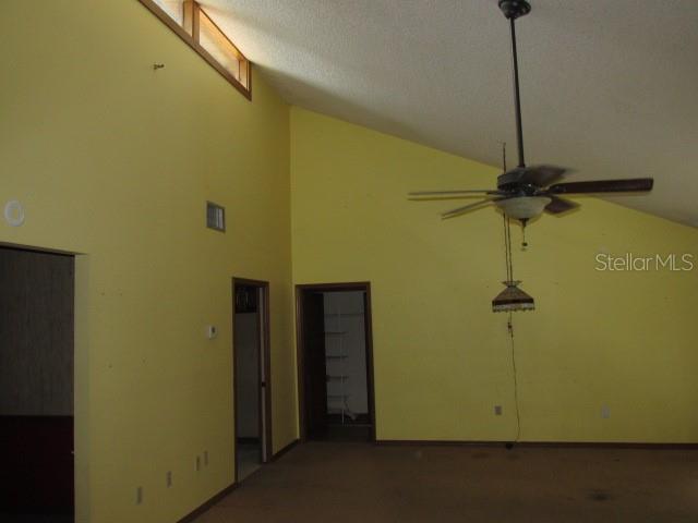 A room with yellow walls, a vaulted ceiling, a ceiling fan, and two doorways — 2617 HOMEWOOD DRIVE, BELLE ISLE, FL