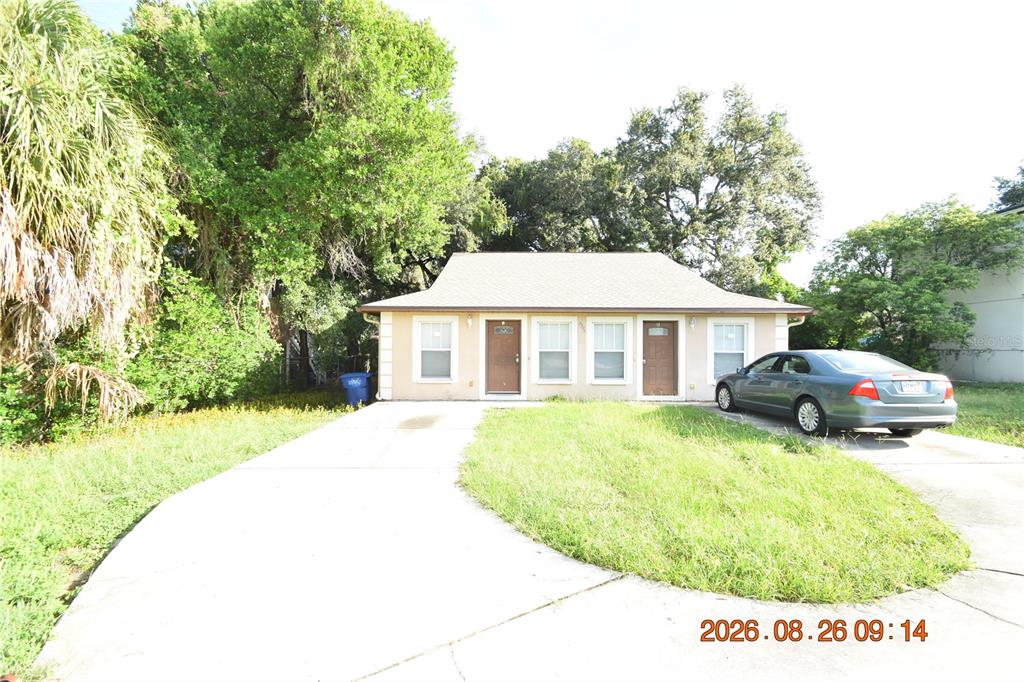 A single-story house with a concrete driveway and a parked car in the front yard — 3506 E 10TH AVENUE UNIT 1/2, TAMPA, FL