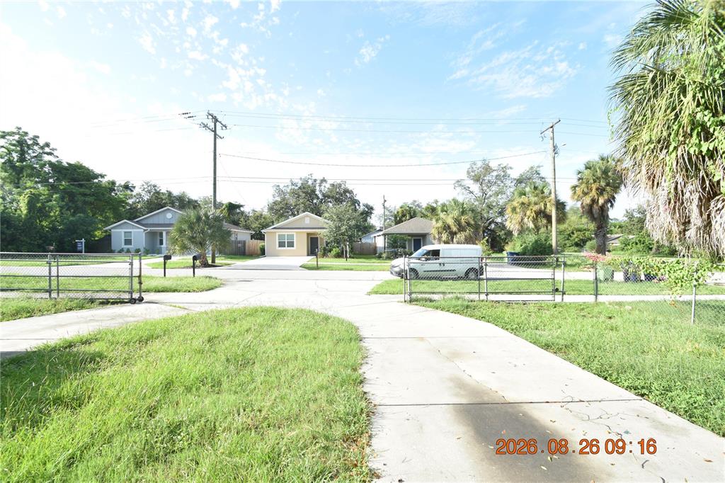 A concrete driveway leads toward two single-story houses behind a chain-link fence — 3506 E 10TH AVENUE UNIT 1/2, TAMPA, FL