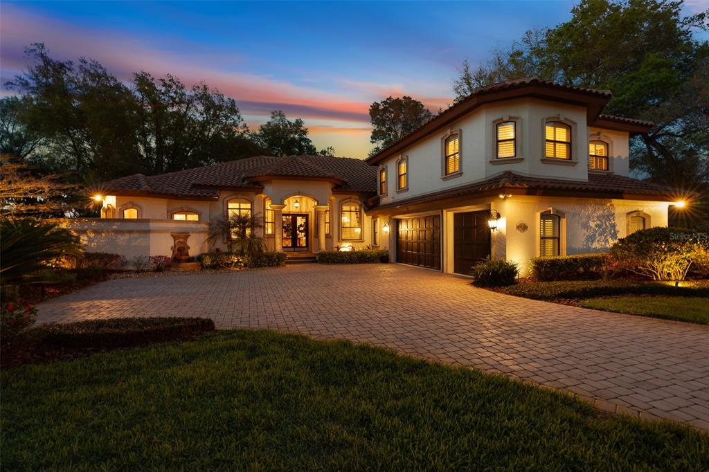 An aerial view of a two-story house with a tile roof and a paved driveway — 7341 BELLA FORESTA PLACE, SANFORD, FL